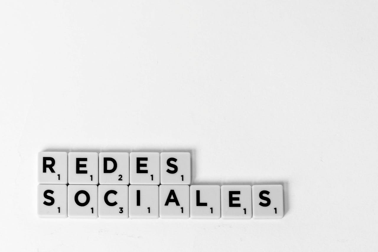Scrabble tiles spelling Redes Sociales illustrating a social media concept on a white background.